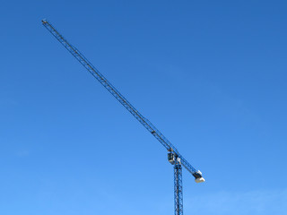 Construction crane. Crane boom against the clear blue sky