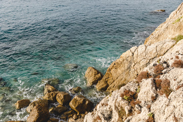 aerial view of small waves crashing on rocky cliff, Nice, France