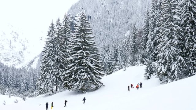 Tourists in mountains taking pictures of the winter landscape