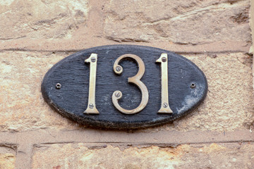 House number 131 sign fixed to wall