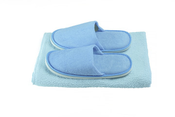 Blue washable slippers with rubber outsole on blue towel isolated on white background