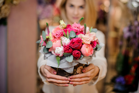 Girl holding a beautiful bouquet of different colour roses
