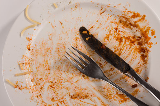 Spaghetti mit Tomatenso&szlig;e Bolognese aufgegessen besteck messer und gabel  leerer Teller