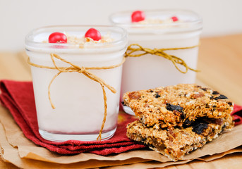 A jars of homemade yogurt and muesli on red cloth