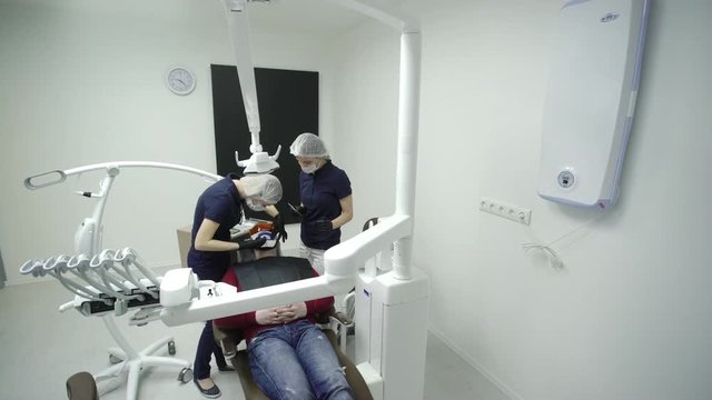 Dentist stomatologist whitening teeth for patient in medicine dental clinic