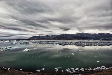 View of the glacier and the lake with ice. Beautiful northern landscape.  Iceland. Dramatic, severe appearance.
