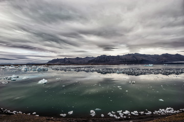 View of the glacier and the lake with ice. Beautiful northern landscape.  Iceland. Dramatic, severe appearance.
