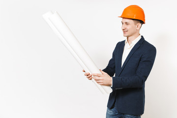 Young handsome smiling businessman in dark suit, protective construction orange helmet holding...