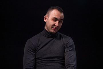 Fototapeta premium Sceptical sitting young man