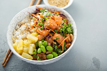 Poke bowl with raw salmon, rice and vegetables