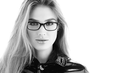 Black and white portrait closeup. Stylish young woman in glasses with a sensual look. Light makeup and shiny lips, long flowing hair