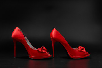 red fashion women shoes on a black background.