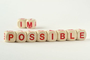 The word possible written with wood blocks - Changing impossible into possible concept