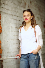 Smiing girl near white brick wall, street lifestyle, walk