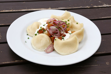 Dumplings with sour cream, bacon and onion