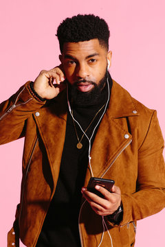 Cool African American man with beard, isolated on pink studio background