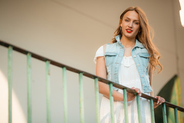 Fototapeta premium Young woman on balcony, white background, street lifestyle, walker