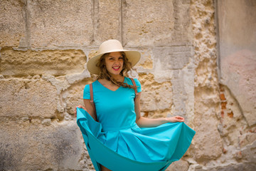 Smiling feminine woman in old city, ancient stone background, street, outdoor