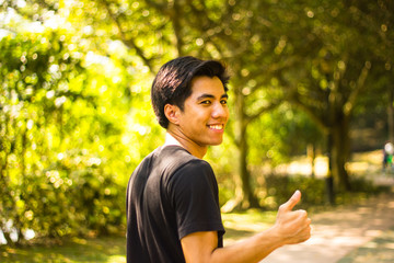 Naklejka na ściany i meble Active Young Malay man show thumbs up in park
