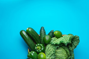 Tray with Fresh Organic Green Vegetables Savoy Cabbage Zucchini Cucumbers Bell Peppers Avocados on Bright Blue Background. Superfoods Vegan Plant Based Diet Concept. Copy Space © olindana