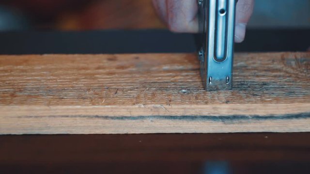 Worker repairing furniture with industrial stapler
