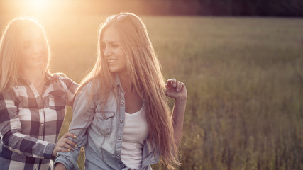 Naklejka premium Two young women walking at sunset