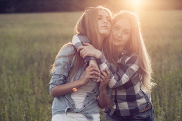Two young girls hugging at sunset
