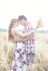 young couple hug in field