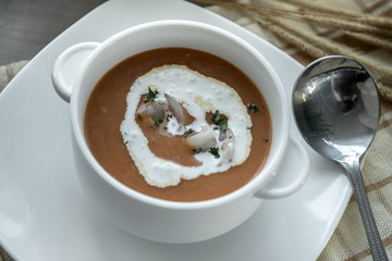 Vegetable cream soup with shrimps in bowl on table