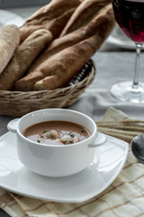 Vegetable cream soup with shrimps in bowl on table