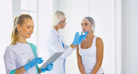 Fototapeta premium Permanent Makeup For Eyebrows. Beautiful Woman With Thick Brows In Beauty Salon. Beautician Doing Eyebrow Tattooing For Female Face. Beauty Procedure