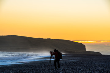 Einsamer Fotograf am blauen Meer bei Sonnenuntergang