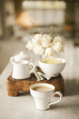 Coffee filled cup on marble counter in white kitchen