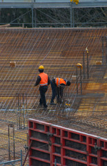 2 workers are working in a foundations of a wellness center under construction