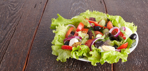 salad from fresh vegetables in a plate on a table, selective focus