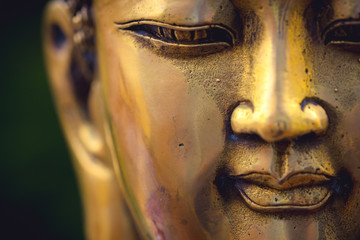 close up of a golden colored buddha head on black background ; China