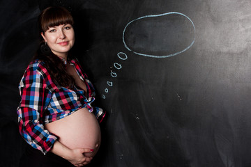 Pregnant women is waiting for baby boy on the black chalkboard background