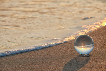 Fototapeta na wymiar Arte attraverso la sfera di cristallo,tramonto in spiaggia