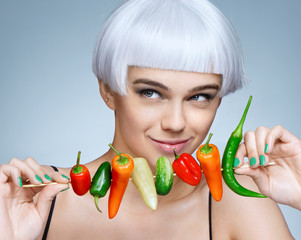 Beautiful young girl with different peppers. Close up. Healthy lifestyle