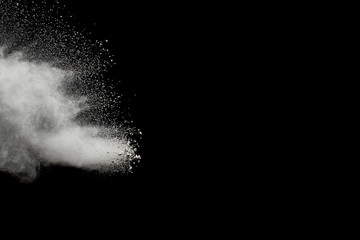 White powder explosion on black background.Stopping the movement of white powder on dark background. Launched white powder splash.
