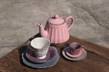 Teapot with teacup on wood background.