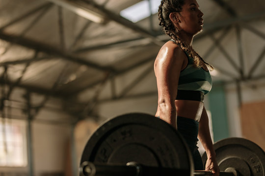 Muscular woman doing heavy weight exercises