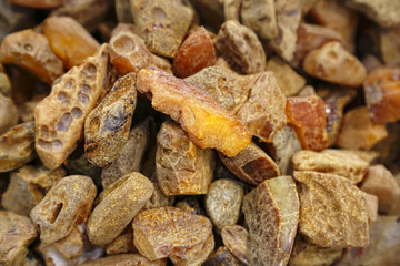 Amber background. A lot of beautiful polished amber stones of different colors. A bunch of natural minerals for jewelers. Raw materials for making ornaments. Large pieces of amber. Sunstone