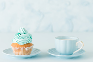 Blue pastel horisontal banner with decorated cupcakes, cup of coffe with milk.