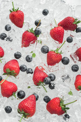 Fototapeta na wymiar Strawberry with blueberries on ice
