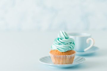 Blue pastel horisontal banner with decorated cupcakes, cup of coffe with milk.