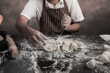 Man preparing buns at table in bakery