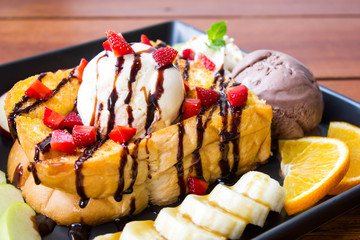 Closeup Honey toast. Sweet dessert served with variety fruit and icecream.