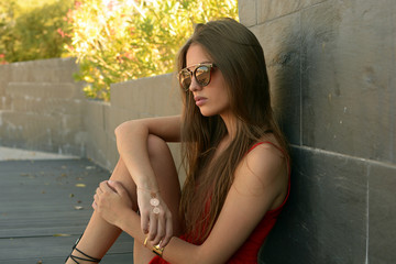 Chica joven con gafas apoyada en la pared