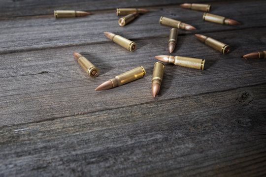 Scattered bullets on wooden background